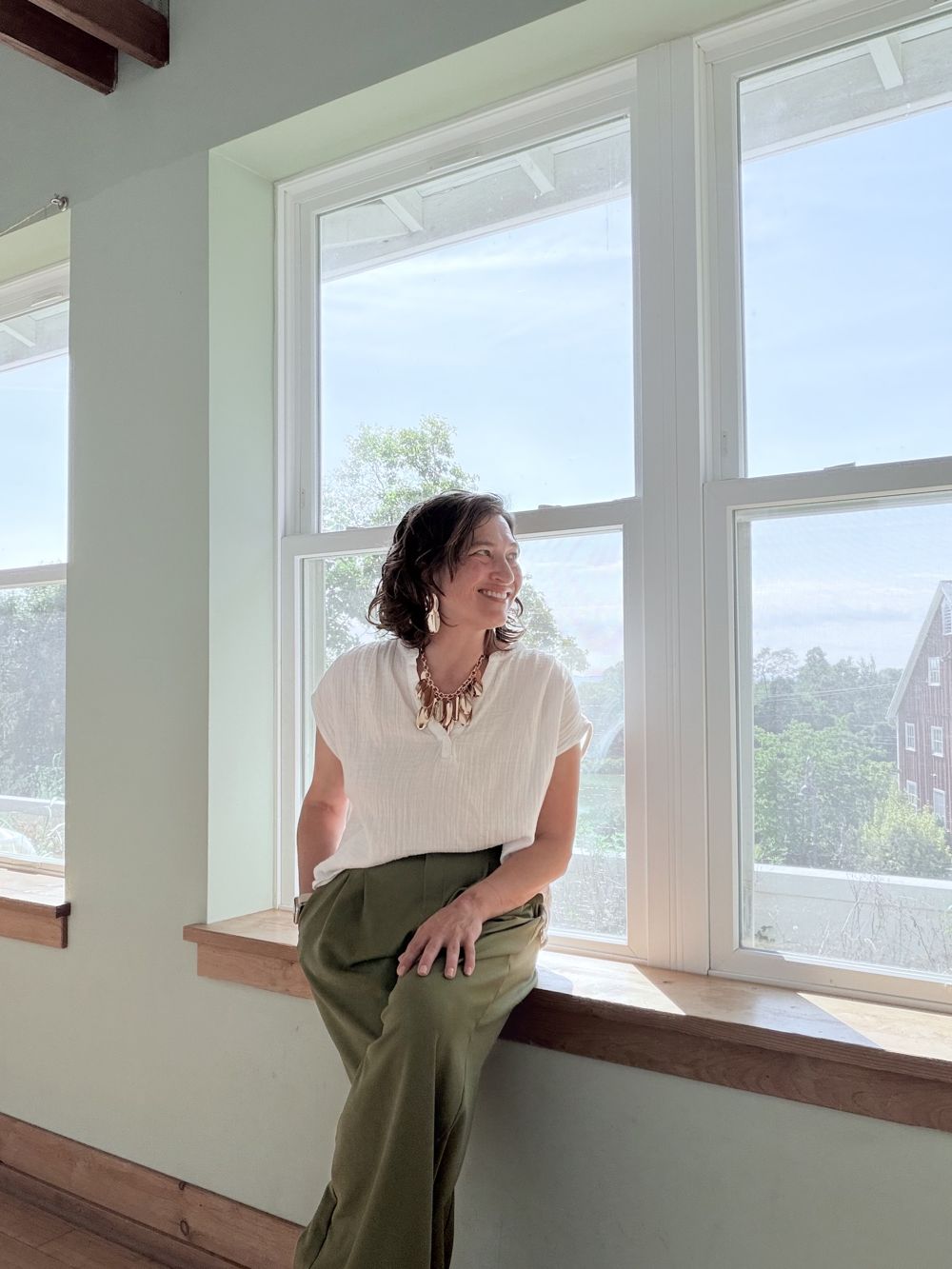 Dr. Angela Hess sitting in a sunny window
